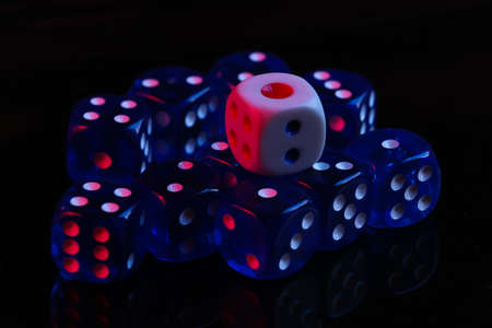 Dice on black background with red blue neon lightの写真素材