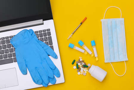 Workspace of doctor with laptop on a yellow background. top view. flat layの写真素材