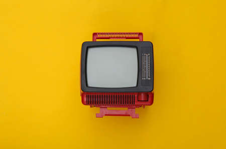 Red retro old mini tv set on yellow background. top viewの写真素材