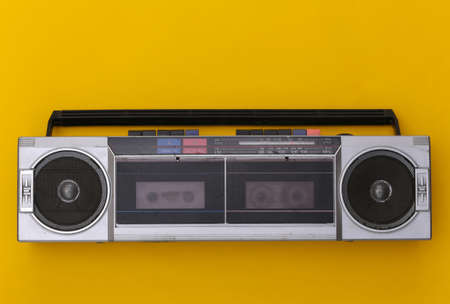 80s Retro Outdated Portable Stereo Radio Cassette Recorder on Yellow Background. top viewの写真素材