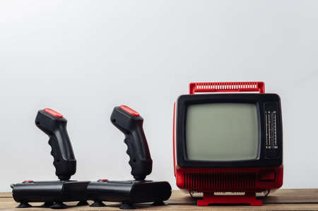 retrogaming. Video game competition. Old TV with two joysticks on a white background. Attributes 80sの写真素材