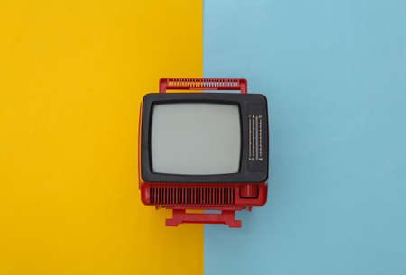 Red retro old mini tv set on yellow blue pastel background. top viewの写真素材