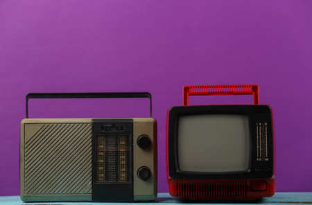 retro media. Old portable tv, radio receiver on a purple backgroundの写真素材
