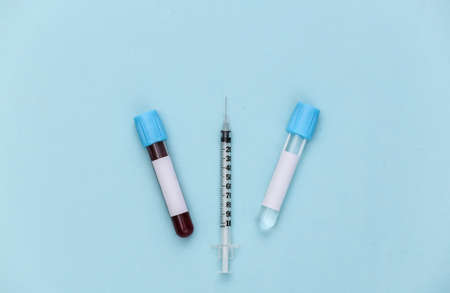 blood test. Test tubes with a syringe on blue background. top view