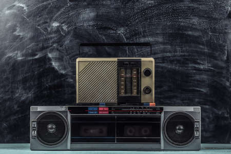 80s Retro outdated portable stereo cassette recorder and radio receiver on blackboard backgroundの写真素材