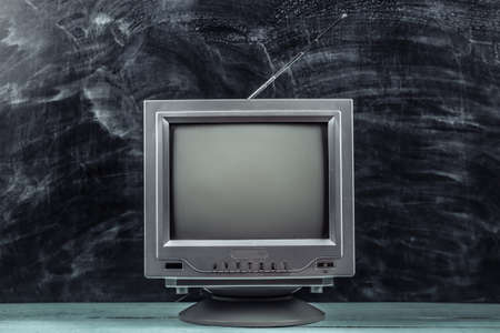 Red retro old school portable mini tv set on blackboard backgroundの写真素材