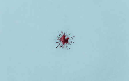 Drop of blood on a blue background.