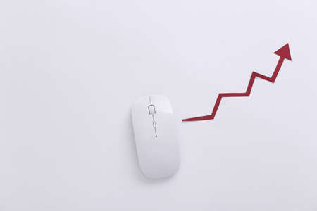 White mouse with a rising arrow on white background. Online business, trading. top view. flat lay