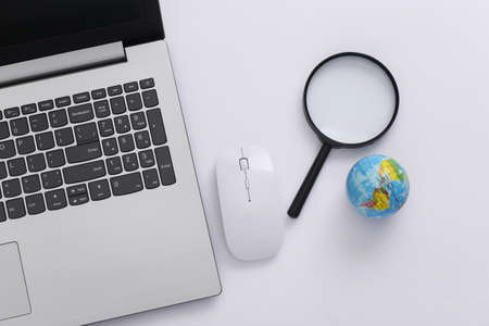 search information. Laptop with pc mouse, magnifier, globe on white background. top viewの写真素材
