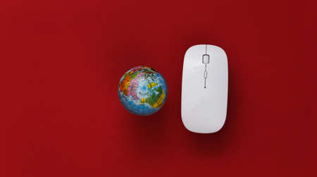 global network. Pc mouse and globe on red background. online business. top view. flat layの写真素材
