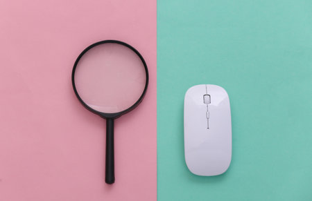 search information. Pc mouse, magnifier on pink blue pastel background. top viewの写真素材