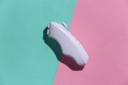 Modern controller (joystick) on a blue-pink pastel background with shadow. top view. gadget and device. flat layの写真素材