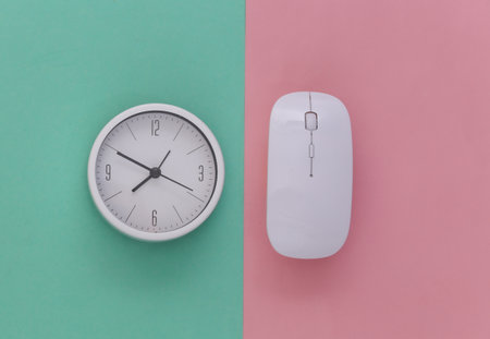 Clock with pc mouse on pink blue background. Working Deadline. top view.の写真素材