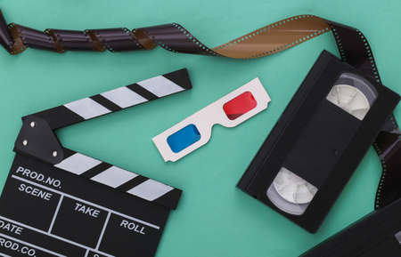 Retro Movie clapper board and video cassette, film, 3d glasses on mint color background. Filmmaking, Movie production. 80s. top viewの写真素材