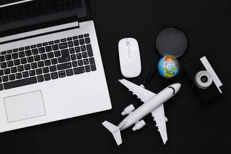 Flat lay composition of laptop and travel accessories on black background. tourism. top view.の写真素材