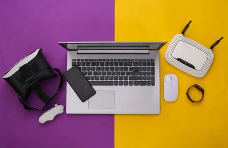 Modern youth gadgets and devices on purple yellow background. top view. flat layの写真素材