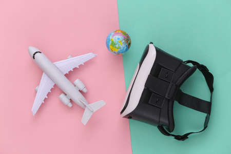 Virtual travel. Virtual reality headset with plane, globe on pink blue background. top view