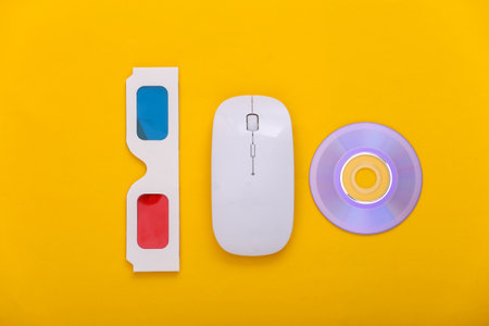 Pc mouse with anaglyph 3d glasses, CD on yellow background. entertainment. top view