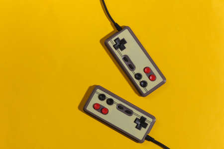Retro gamepads on yellow background with shadow. retro gaming. top view
