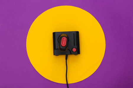 Retro joystick on purple background with yellow circle. Conceptual studio shot. minimalism. top view