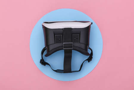 Virtual reality headset on pink background with blue circle. Conceptual studio shot. minimalism. top...
