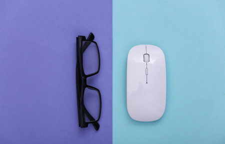 Pc mouse with glasses on purple blue pastel background. top view