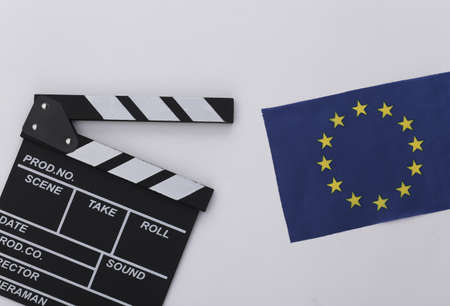 Movie clapper board and EU flag on white background. Filmmaking, Movie production, Entertainment...