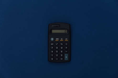 Calculator on classic blue background. Color 2020. Top view.