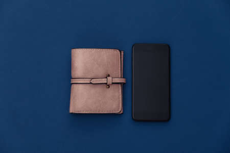 Smartphone and wallet on a classic blue background. Color 2020. Top view.の写真素材