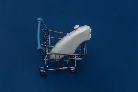 Shopping trolley with modern joystick on classic blue background. Color 2020