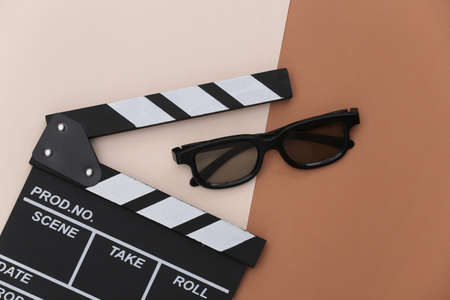 Movie clapper board and 3d glasses on beige brown background. Filmmaking, Movie production, Entertainment industry. top viewの写真素材