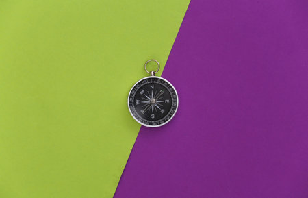 Compass on purple green background. top view. Minimalism travel concept. flat layの写真素材