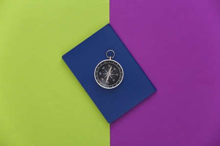Compass and passport on purple green background. top view. Minimalism travel concept. flat layの写真素材