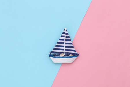 Sailboat on a blue pink background. Travel minimalism concept. top view. flat layの写真素材