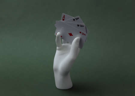 White mannequin hand with four aces stands on green background. Poker, card gameの写真素材