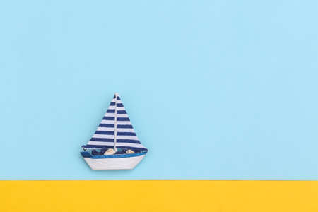 Sailboat on a blue-yellow background. Travel minimalism concept. top view. flat lay