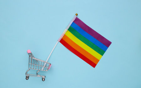 Shopping trolley with LGBT rainbow flag on blue background. Gay parade, freedom, toleranceの写真素材