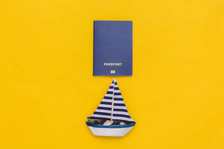 Sailboat and passport on yellow background. travel concept. top viewの写真素材