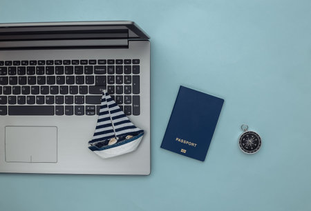 travel planning. Laptop and sailboat, compass, passport on blue background. top view. flat layの写真素材