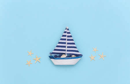 Sailboat with starfish on a blue background. Travel minimalism concept. top view. flat lay