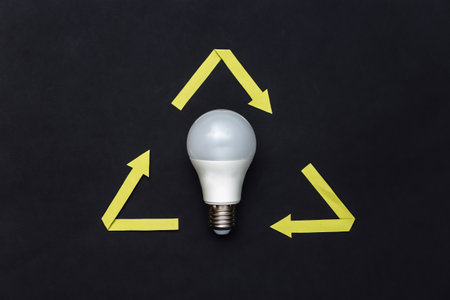 Recycled arrows sign and led light bulb on black background. top viewの写真素材