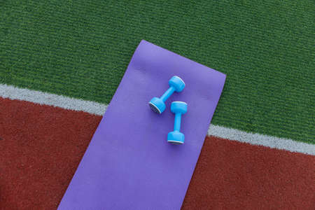 Dumbbells with a mat at the stadium. outdoor workoutの写真素材