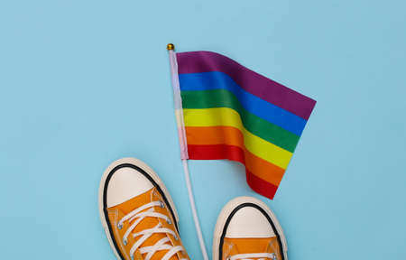 LGBT rainbow flag and sneakers on blue background. Tolerance, freedom, gay paradeの写真素材