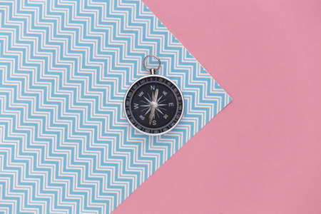 Compass on a blue-pink pastel background. top view. Minimalist travel concept. flat layの写真素材