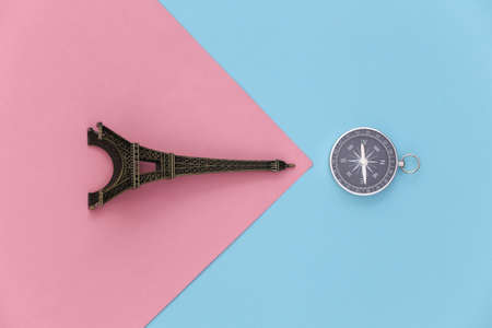 Minimalism travel, adventure flat lay. Camera and eiffel tower figurine on a blue-pink pastel background. top viewの写真素材