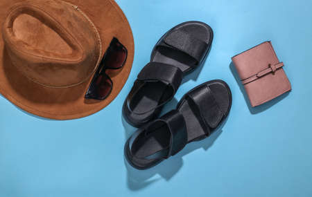 Flat lay composition of women's accessories on a bright blue background. Stylish fashion concept or travel. top viewの写真素材
