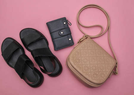 Women's leather sandals, wallet and bag on pink pastel background. Women's accessories. top view. flat layの写真素材