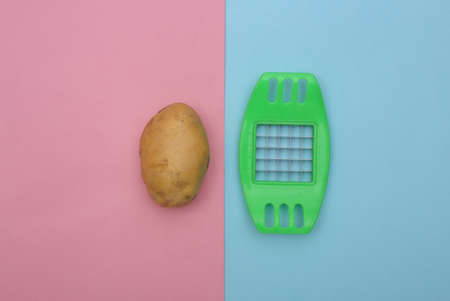 Kitchen tool for cutting and potato on blue pink background. top viewの写真素材