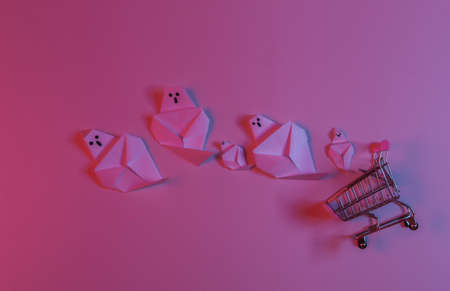 Paper Origami ghosts and shopping trolley in red blue neon light. Halloween theme