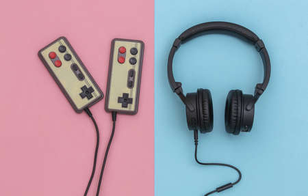 Retro joysticks and headphones on pink blue pastel background. Gaming. top viewの写真素材